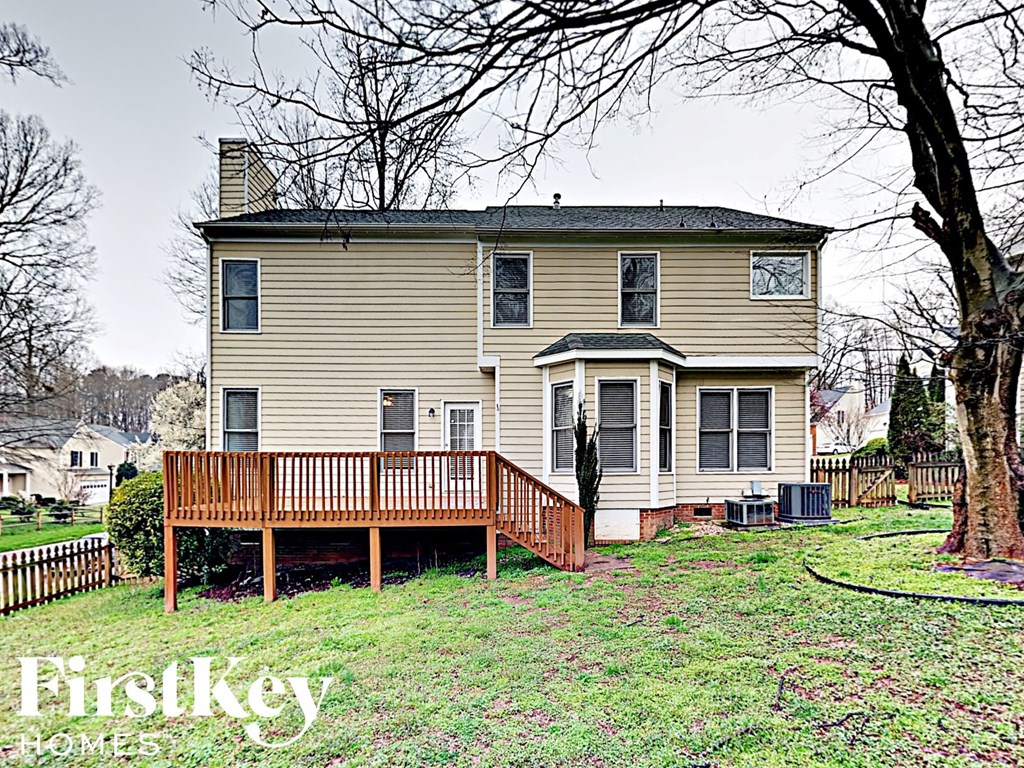 a yellow house with a wooden deck on a hill