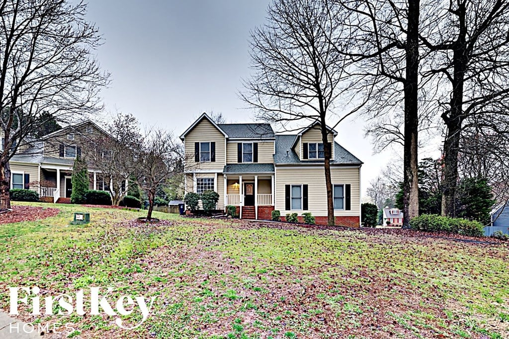 a blue and white house with a yard covered in flowers