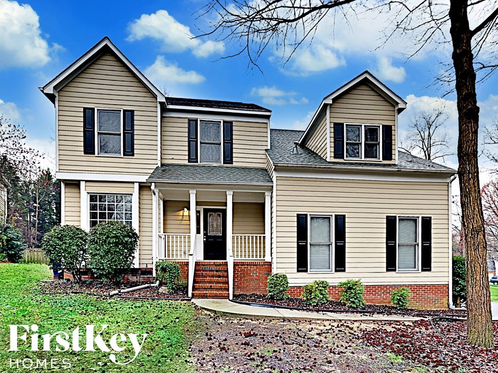 a beige house with black shutters on a sunny day