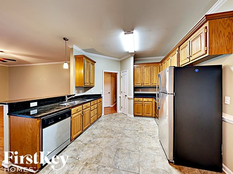 a kitchen with wooden cabinets and a black refrigerator