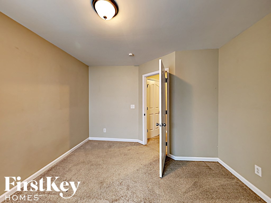 a bedroom with a door to a closet and a carpeted floor