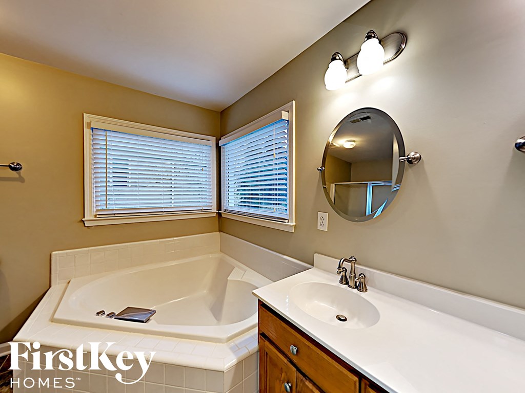 a bathroom with a tub and a sink and a mirror