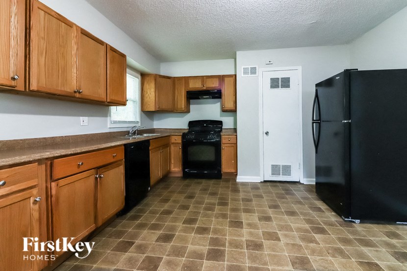 a kitchen with black appliances and wooden cabinets