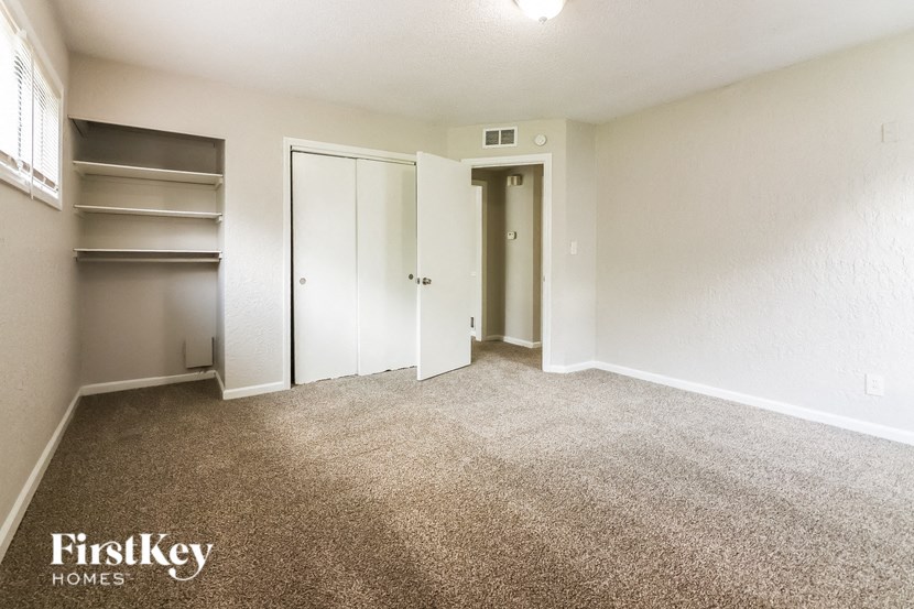 an empty living room with carpet and a closet