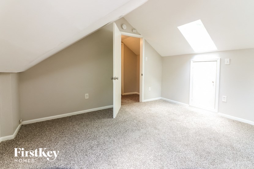 a bedroom with a white carpet and a door to a closet