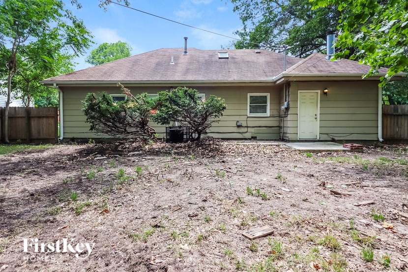 a small green house with a yard in front of it