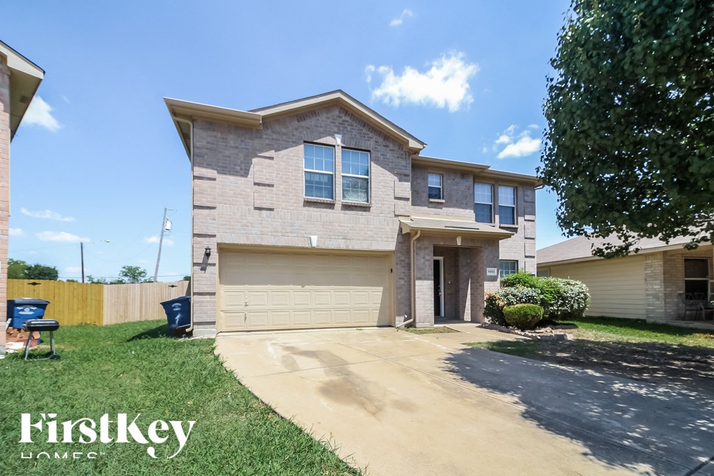a beige and white house with a driveway and lawn