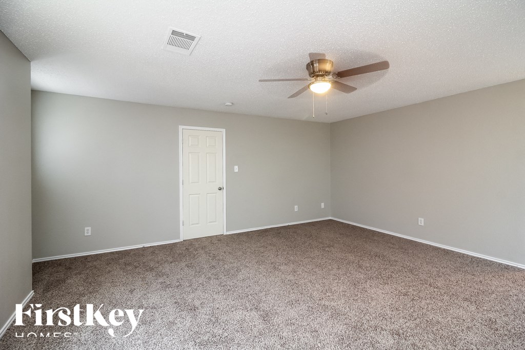 the living room of an empty house with a ceiling fan