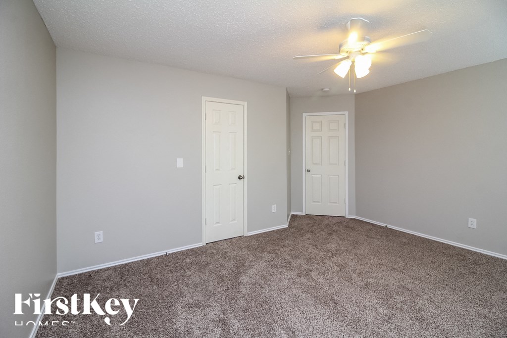 the spacious living room with carpeting and a ceiling fan