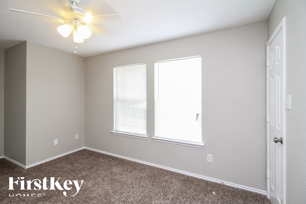 the upstairs bedroom has carpet and a ceiling fan