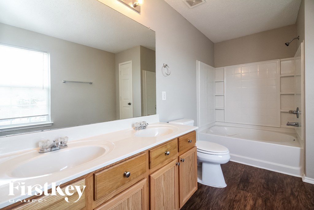 a bathroom with two sinks and a toilet and a tub
