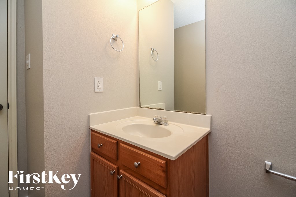 the bathroom has a large mirror and a sink