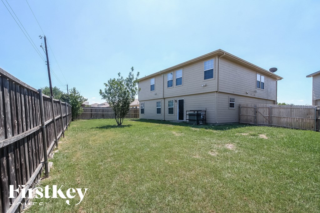 the backyard of a house with a yard and a fence