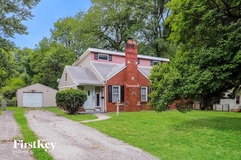 a red brick house with a white garage and a driveway