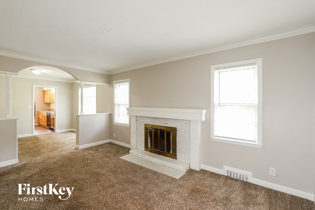 a living room with a fireplace and a carpeted floor