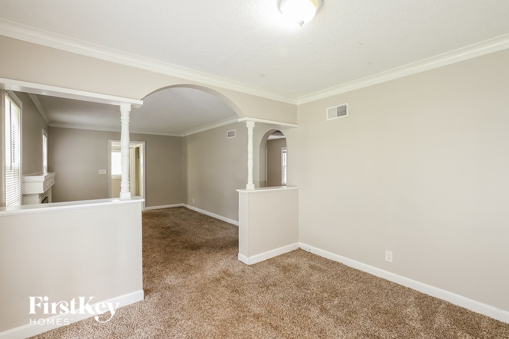 a spacious living room with carpeting and white walls