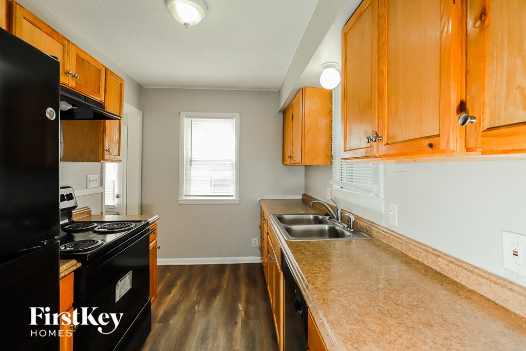 a kitchen with wood cabinets and black appliances and a sink