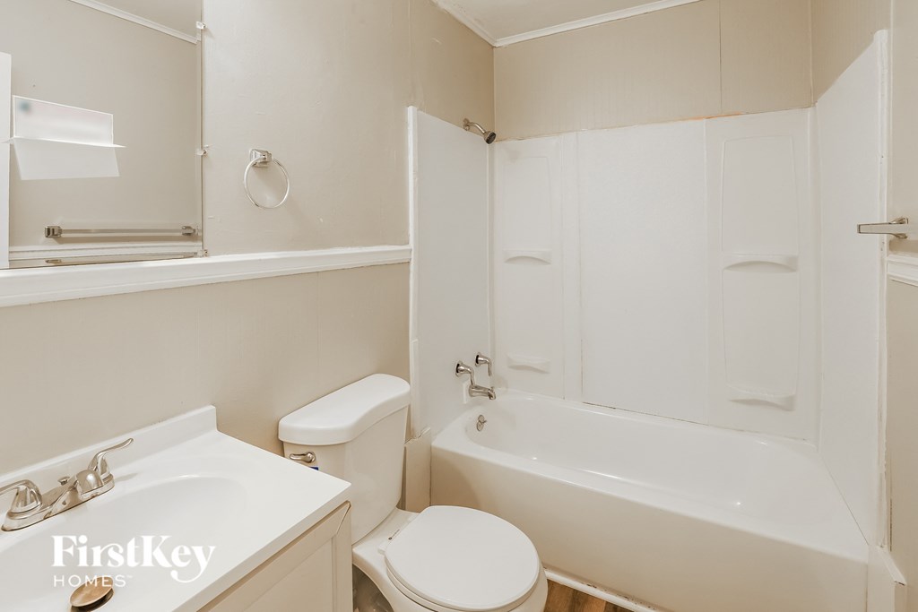 a white bathroom with a toilet and a tub and a sink