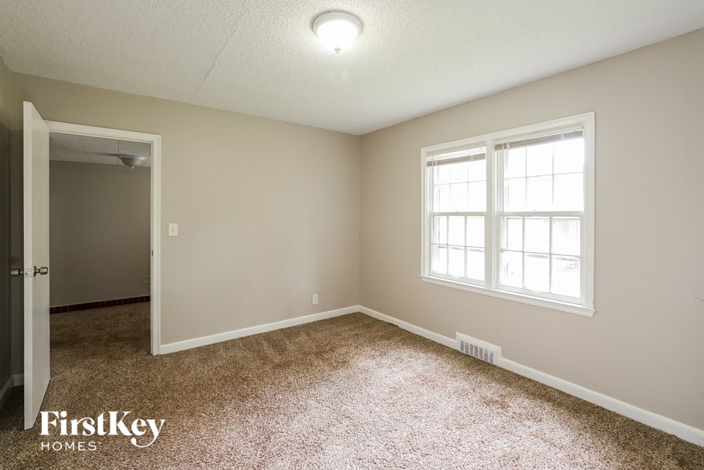 a bedroom with a carpeted floor and a window