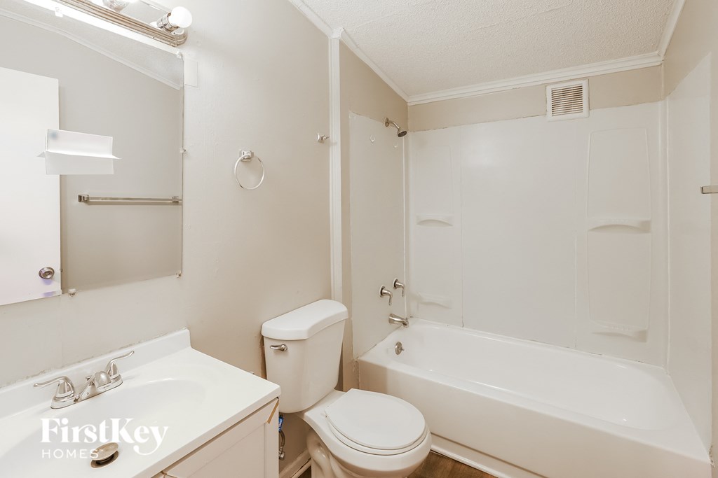 a white bathroom with a tub and a toilet and a sink