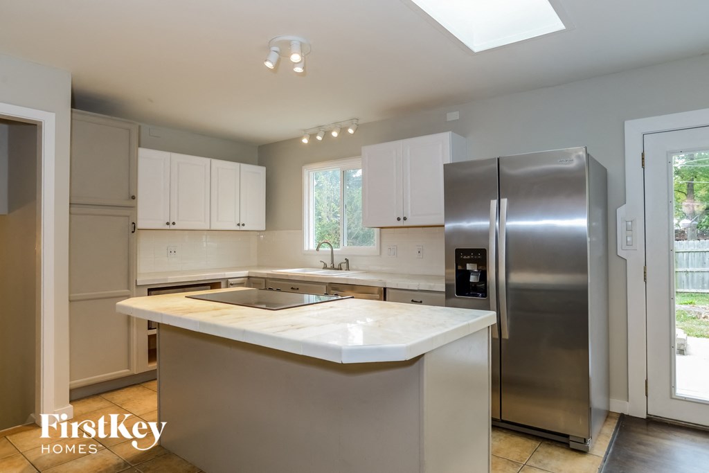 an updated kitchen with stainless steel appliances and white counter tops