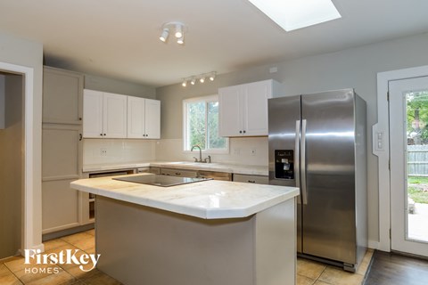 an updated kitchen with stainless steel appliances and white counter tops