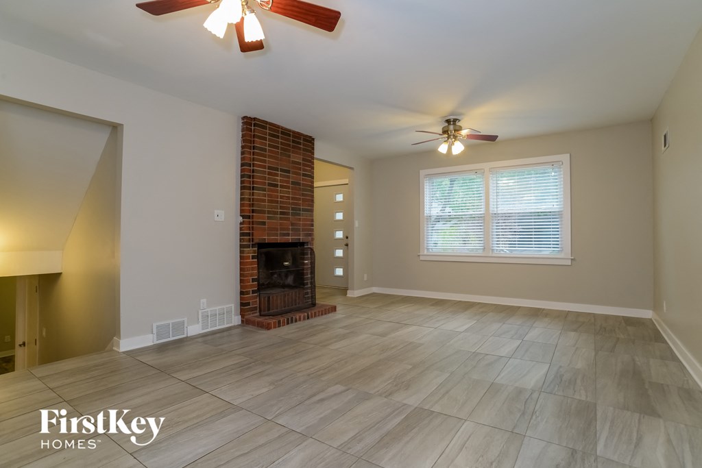 a living room with a fireplace and a ceiling fan