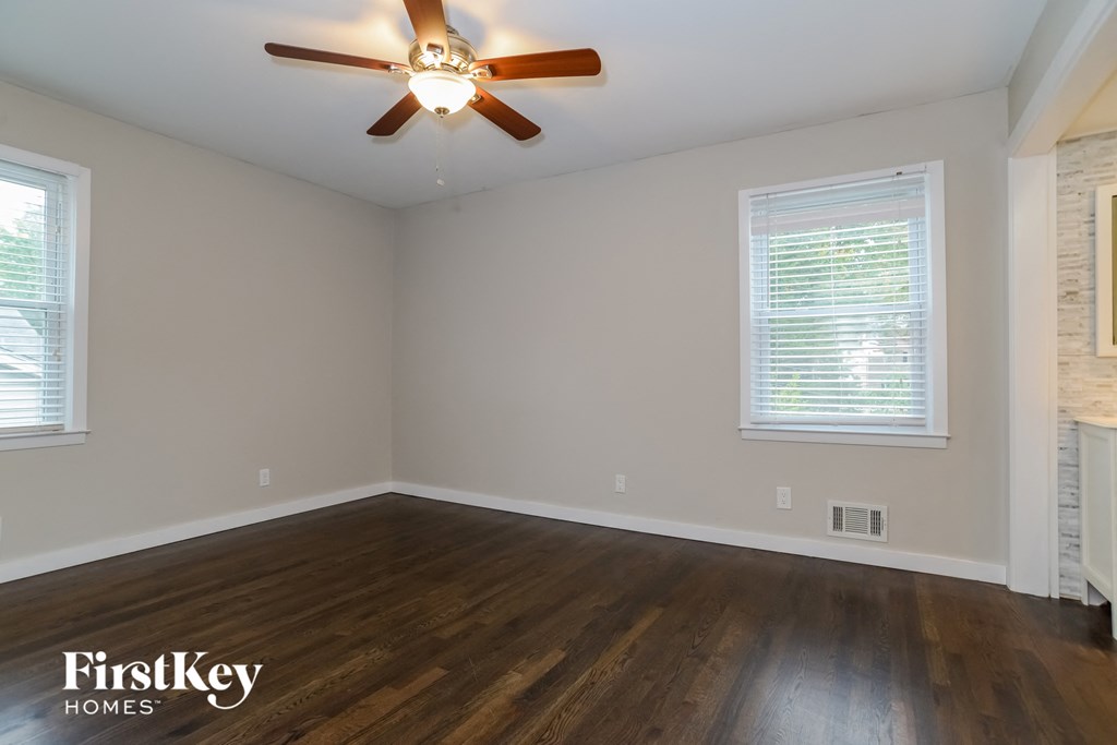 the bedroom with hardwood flooring and a ceiling fan