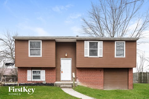 A brown house with a white door and windows is for sale.