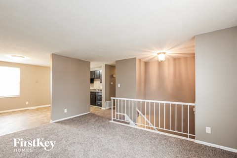 A spacious room with a balcony and a kitchen area.