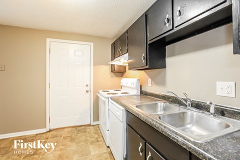 A kitchen with a white door and a sink.