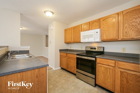 A kitchen with wooden cabinets and a stove top oven.