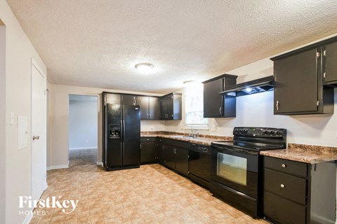 A kitchen with black appliances and cabinets.