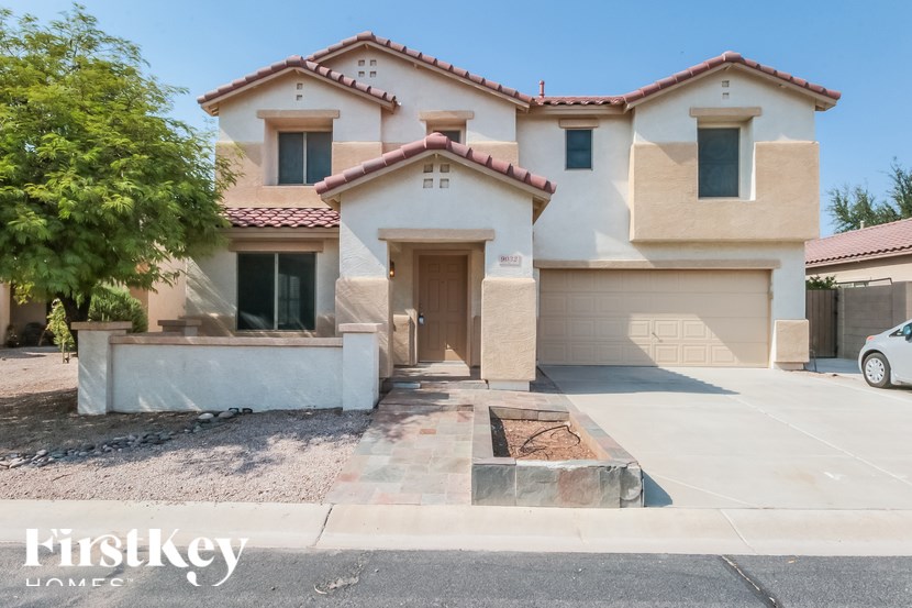 A house with a brown roof and a garage is for sale.