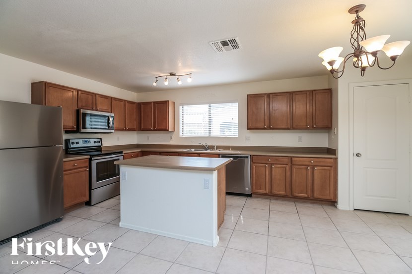 A kitchen with a refrigerator, oven, microwave, and cabinets.
