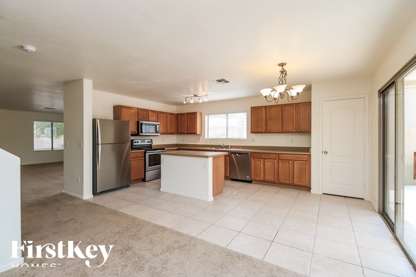 A kitchen with a refrigerator, microwave, and oven.