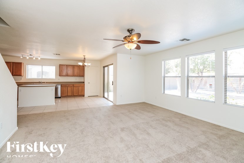 A spacious room with a ceiling fan and a large window.