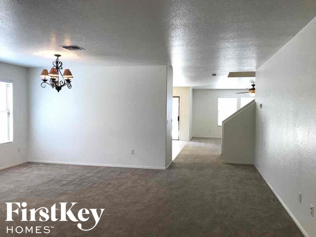 A room with a chandelier and a FirstKey Homes logo.