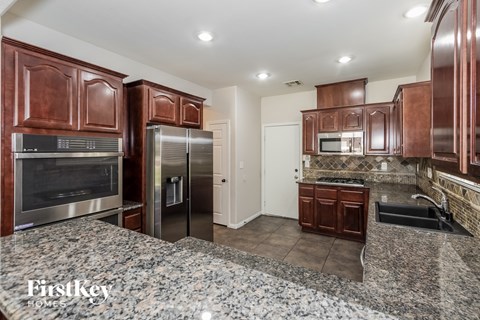 A kitchen with granite countertops and stainless steel appliances.