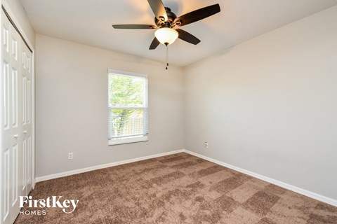 a bedroom with carpet and a ceiling fan