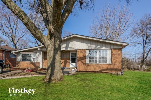a brown brick house with a tree in front of it