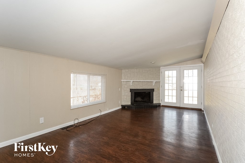 an empty living room with wood floors and a fireplace