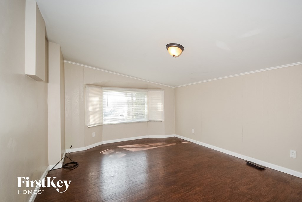 a living room with a hard wood floor and a window