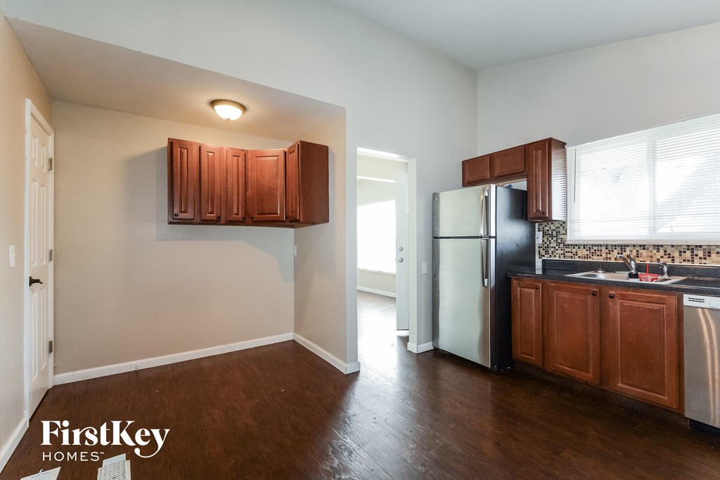 a kitchen with wooden cabinets and a stainless steel refrigerator