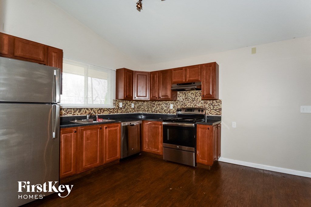 a kitchen with wooden cabinets and stainless steel appliances