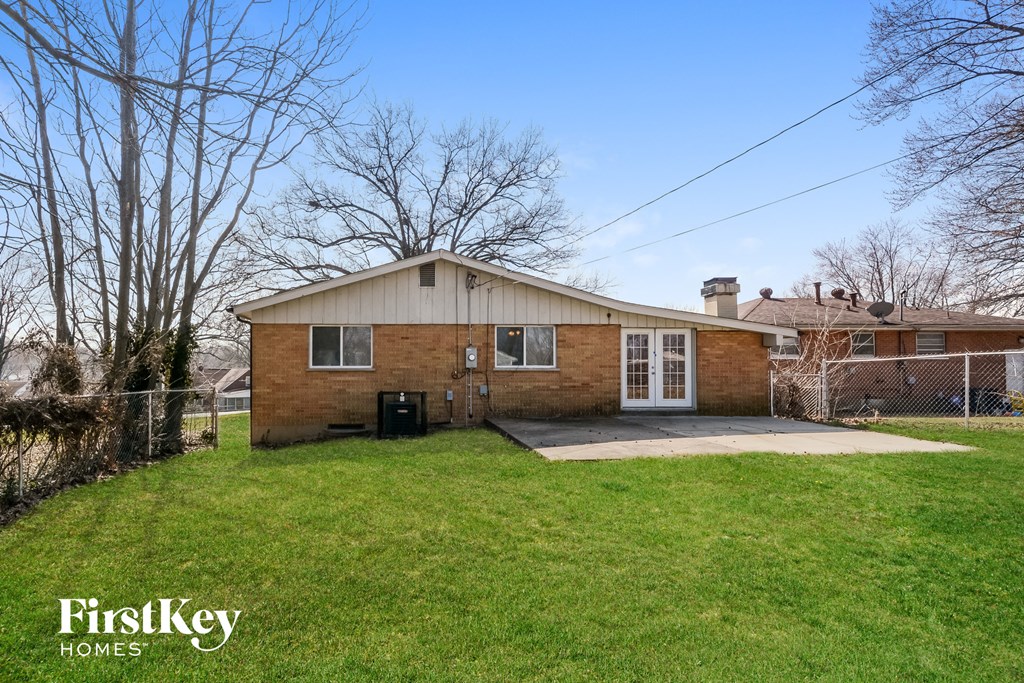 a brick house with a yard and a chain link fence