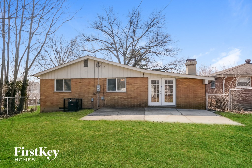 a brick house with white doors and a yard