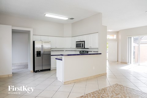 A kitchen with a refrigerator, microwave, and oven.