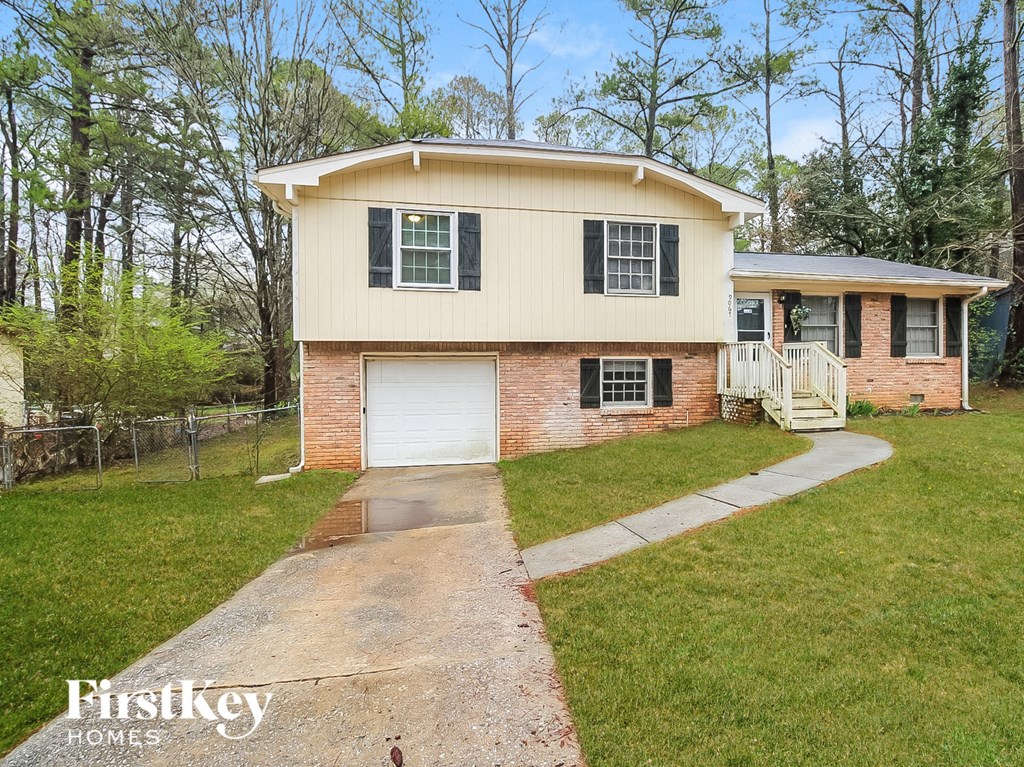a small brick house with a white door and a driveway