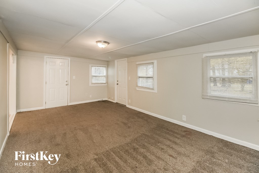 a living room with a carpeted floor and a white door and window